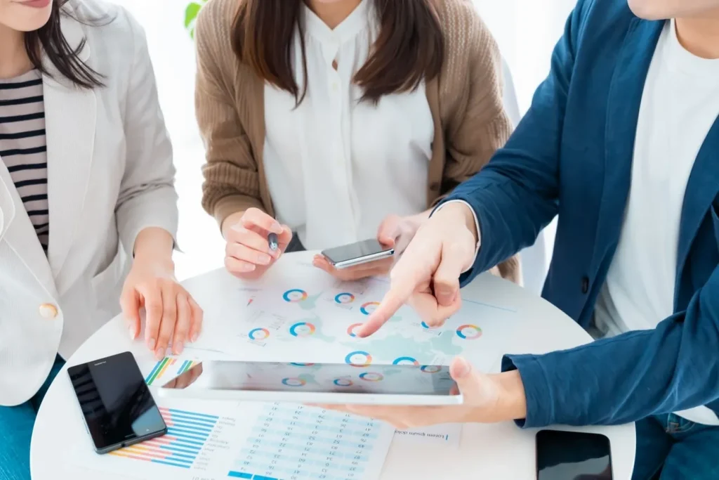 応募を増やすために求人情報を確認している、3人の男女