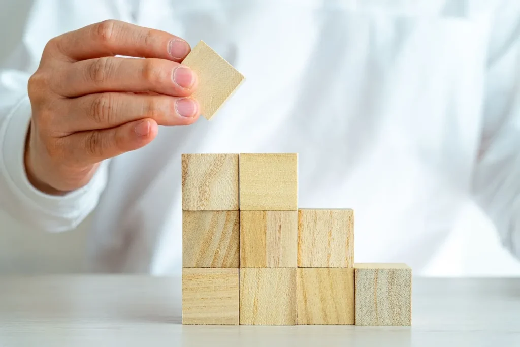 ブロックを積み上げてつこ氏ずつ完成させていく男性