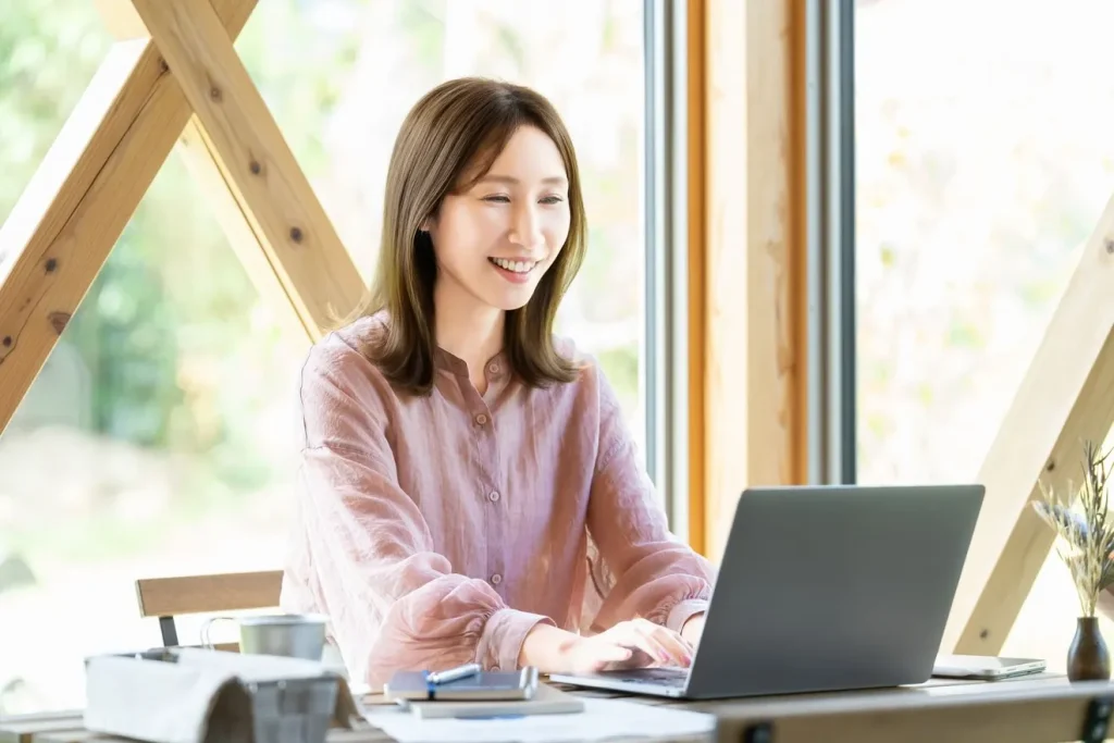 笑顔でホームページを更新する女性