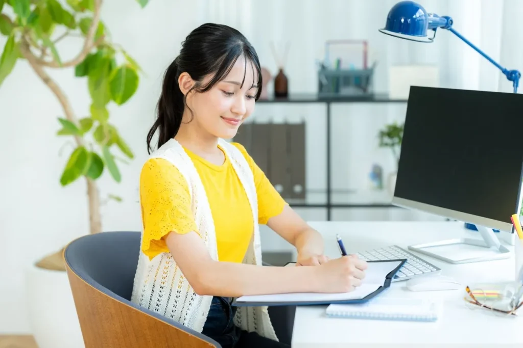 事業の目的をノートに書いている女性