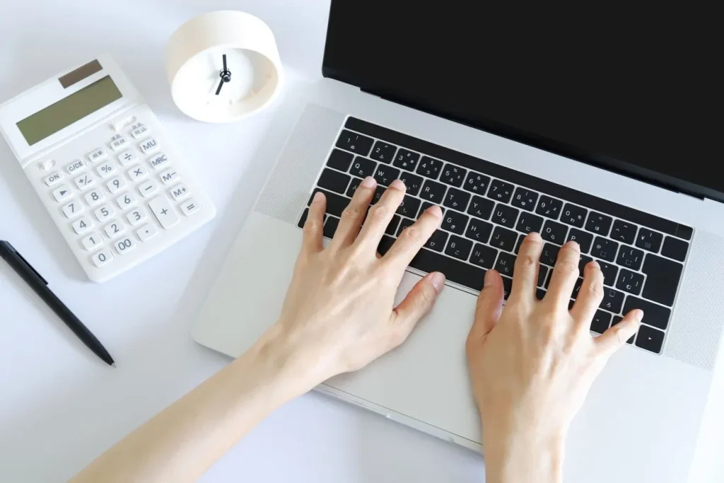 パソコンを操作する人と時間とコストのイメージ