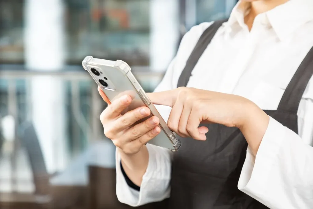 スマートフォンを操作する女性店員