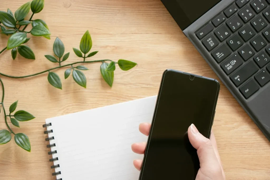 スマホを操作する人とノート