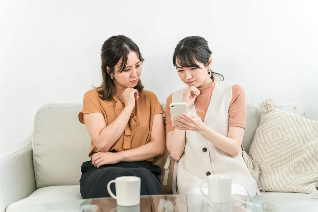 サロンのSNSを見て怪訝な顔をしている女性2人