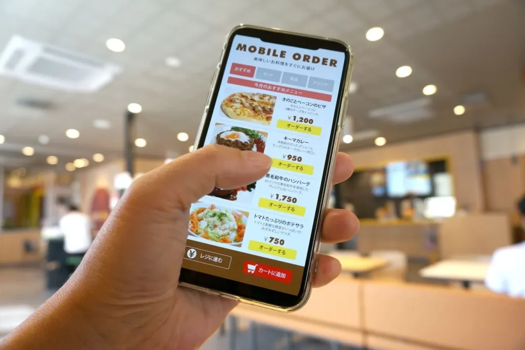 スマートフォンでモバイルオーダーシステムを操作する人