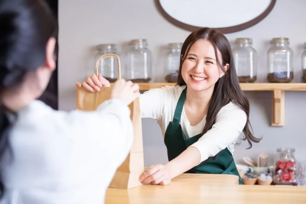 お客様にテイクアウト商品を渡す店員