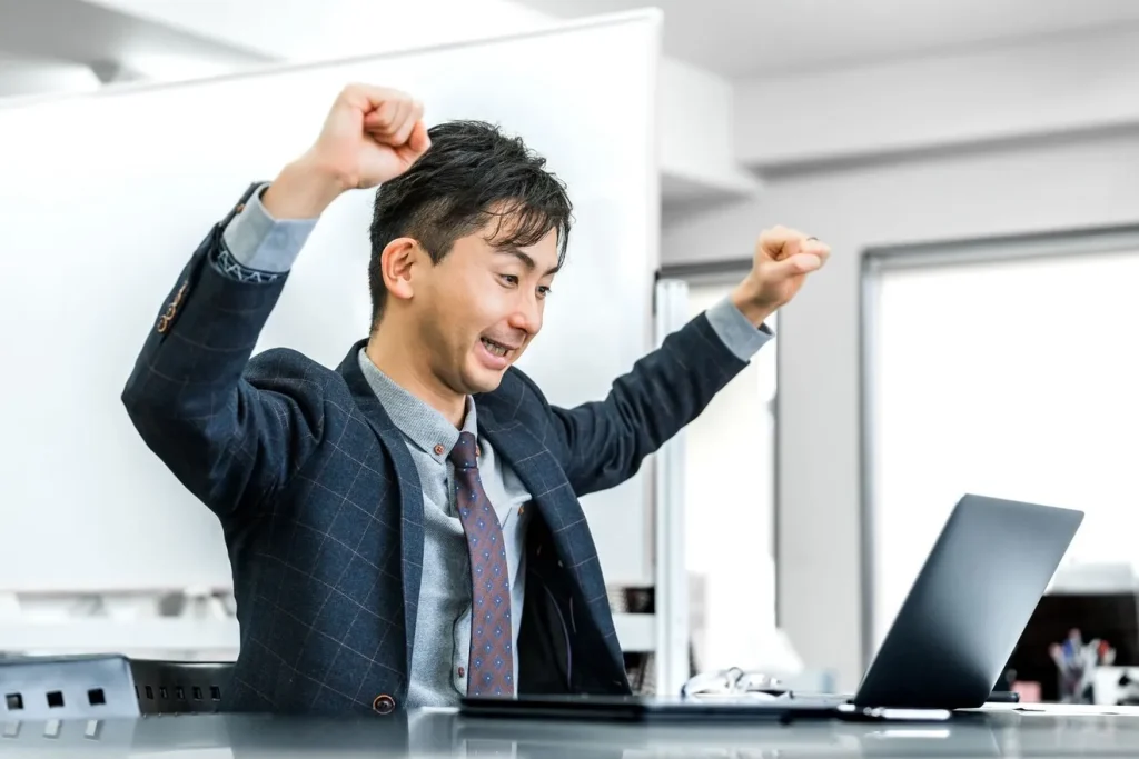 見積もりフォームの利用数が増えてガッツポーズをしているビジネスマン