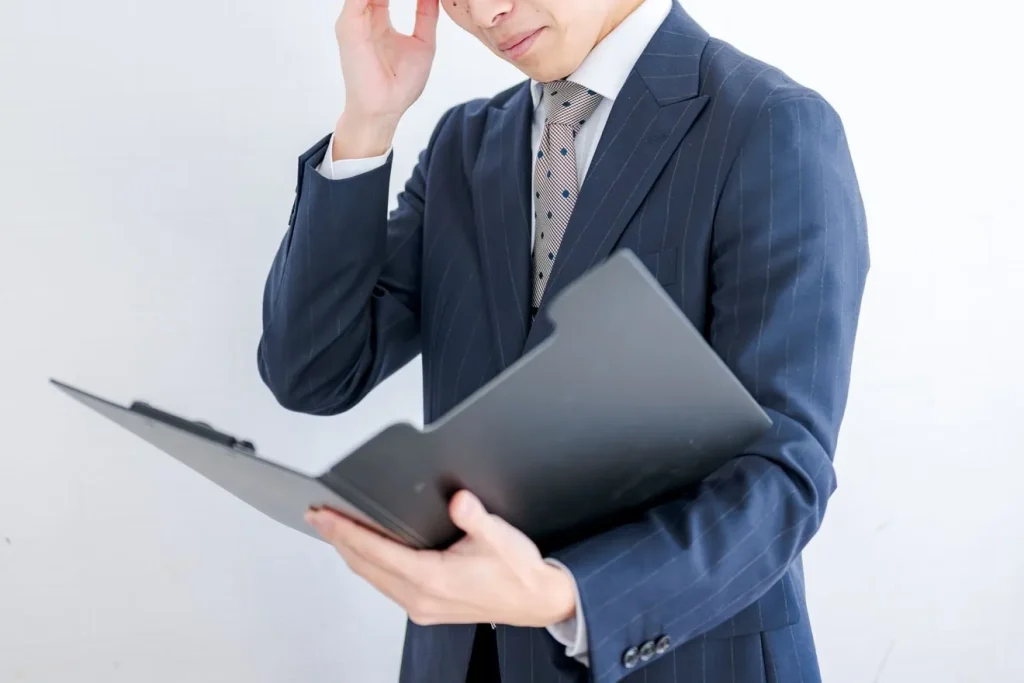 ファイルを見ながら困っている男性