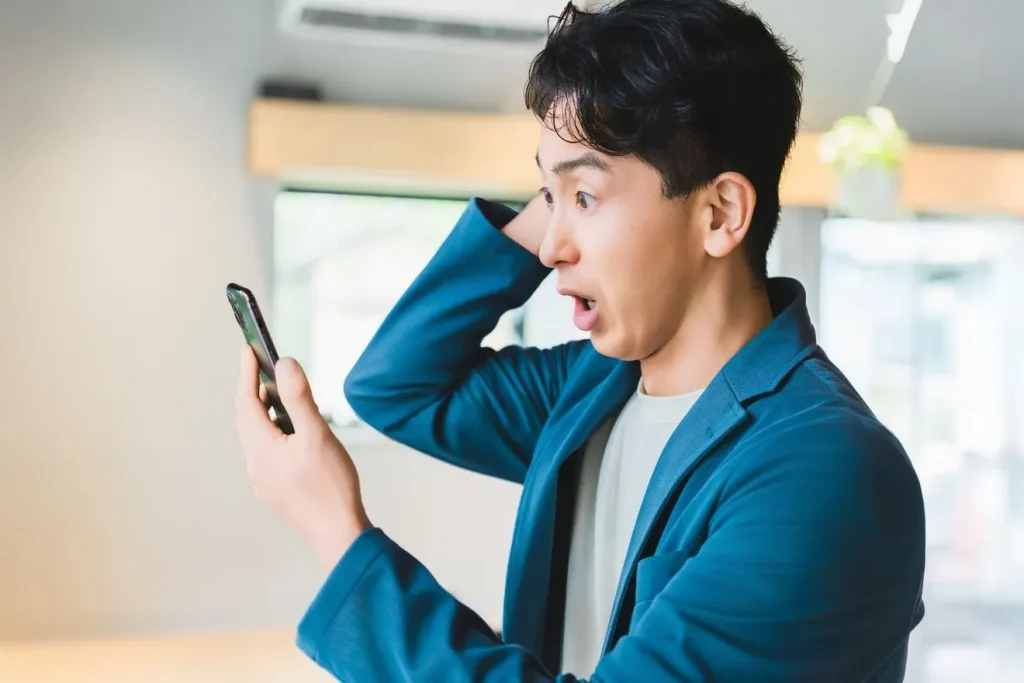 自社サイトをスマホで見て驚いている男性
