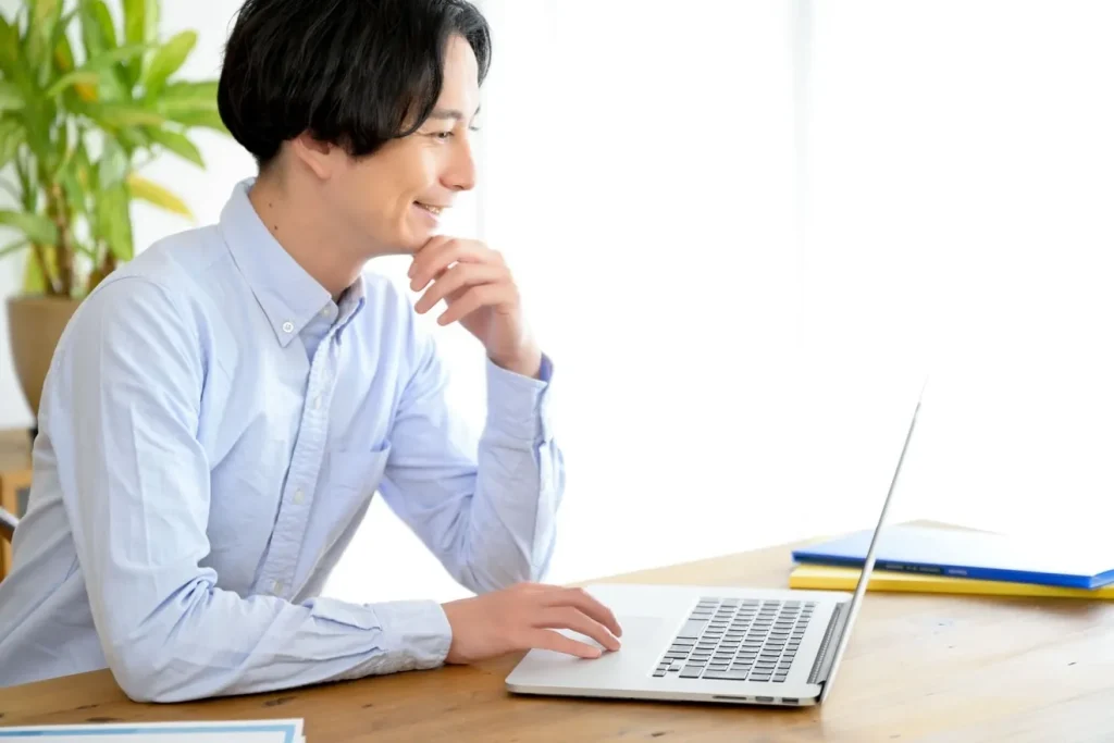 笑顔でパソコンの操作をする男性