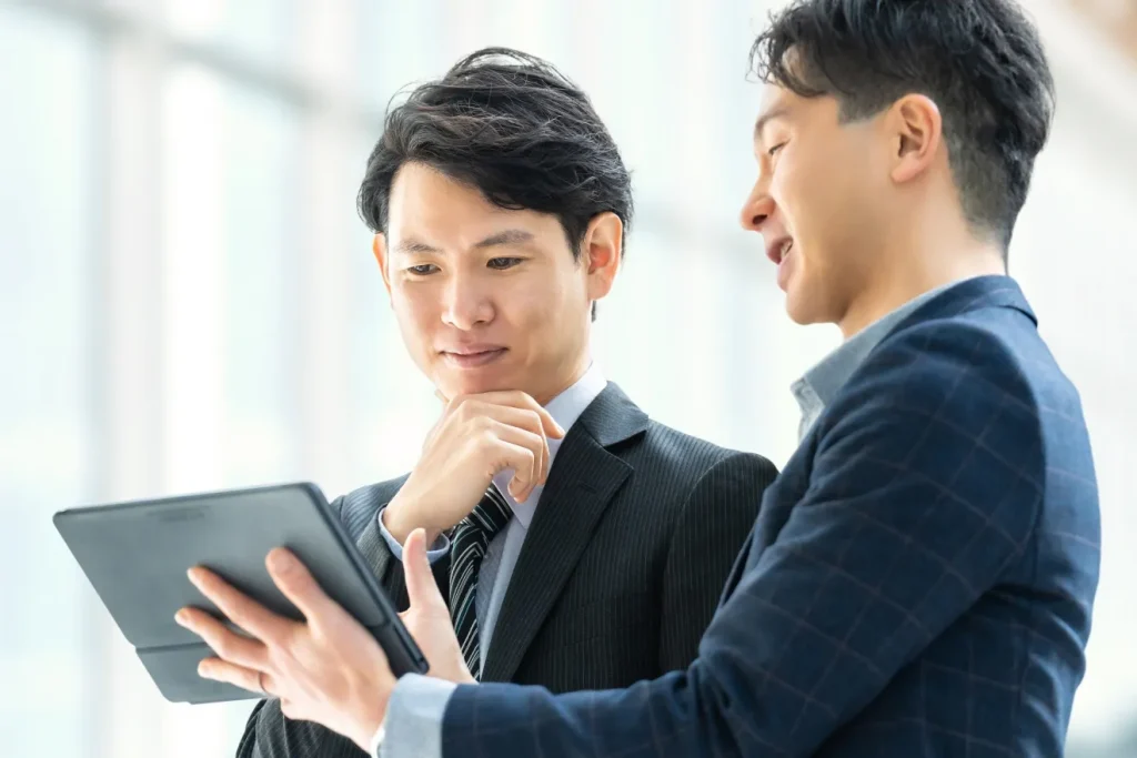 タブレットを見て問い合わせ相談をする、2人のビジネスマン