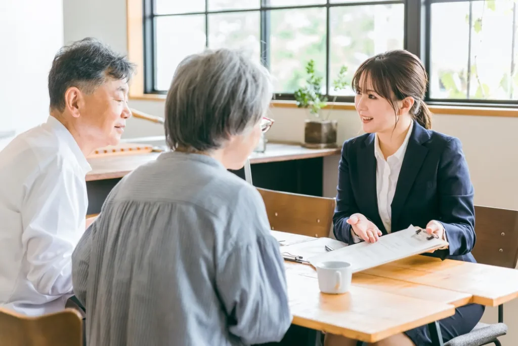 老夫婦に直接見積書を提案するビジネスウーマン