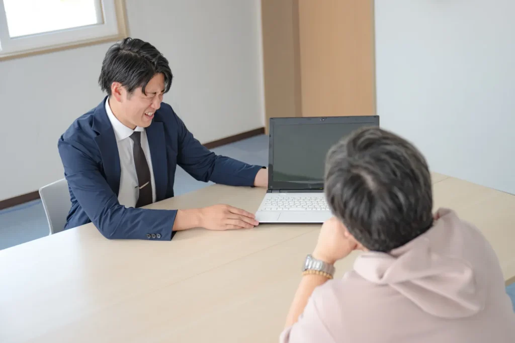 お客さんから値切られて苦しそうな顔をするビジネスマン
